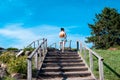 Rear view of a young woman in short shorts climbing stairs in a summer park on a sunny day Royalty Free Stock Photo