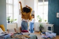 Rear view of young woman sorting wardrobe indoors at home, charity donation concept.