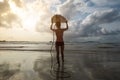 Rear view of young woman surfer with white surfboard Royalty Free Stock Photo