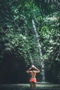 Rear view of Young woman tourist with straw hat in the deep jungle with waterfall. Real adventure concept. Bali island. Royalty Free Stock Photo