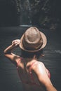 Rear view of young woman tourist with straw hat and red swimsuit in the deep jungle. Real adventure concept. Bali island Royalty Free Stock Photo