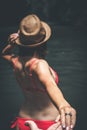 Rear view of young woman tourist with straw hat and red swimsuit in the deep jungle. Real adventure concept. Bali island Royalty Free Stock Photo