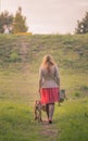 Rear view young woman walking dog Royalty Free Stock Photo