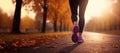 Rear view of young woman walking, exercising and running on the street in the park on an autumn morning.