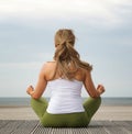 Rear view young woman in yoga pose at the beach Royalty Free Stock Photo