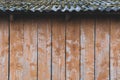 The rear wall of old barn with a slate roof, the roof is covered with moss, matting effect, space for text