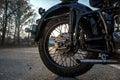 Rear wheels of an old Soviet motorcycle. Close-up. Black motorcycle on the asphalt in the afternoon