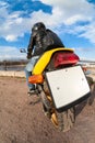 Rear, wide angle view at clear blank license plate of bike, rider sitting on motorbike Royalty Free Stock Photo