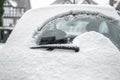 Rear windscreen wiper cleaning snow from heated back window of small car windscreen on fresh icy day early morning frozen glass Royalty Free Stock Photo