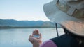 Rear of A woman traveler holding a compass in her hand at sunset lakeside. Lifestyle and Vacation concepts.