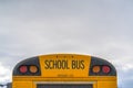 Rear of a yellow school bus with signal lights and emergency exit window Royalty Free Stock Photo