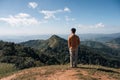 Young asian man standing with looking at mountain view on top of hill at national park Royalty Free Stock Photo