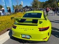 The rearend of a bright green Porsche GT3 at a free car show in a retail store parking lot