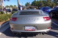 The rearend of a silver gray Porsche Carrera S at a free car show in a retail store parking lot