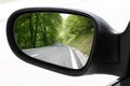 Rearview car driving mirror view forest road Royalty Free Stock Photo