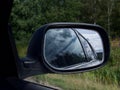 Rearview car driving mirror view green forest road Royalty Free Stock Photo