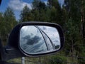 Rearview car driving mirror view green forest road Royalty Free Stock Photo