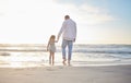 Rearview cute mixed race girl standing hand in hand with her father in the sea at the beach. A young man and his Royalty Free Stock Photo