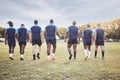 Rearview diverse rugby team walking out onto a field outside for their match. Rugby players entering the field to begin