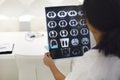 Rearview of ethnic female doctor analyzing X-ray or MRI scan while working in hospital, selective focus. Physician looking at CT