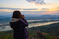 Rearview of female photographer photographing the view of Mekong river on mountain