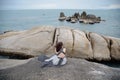 Rearview of a lonely woman sitting on the rock and looking at the sea at Hin Ta Hin Yai Bay, Koh Samui, Surat Thani, Thailand Royalty Free Stock Photo