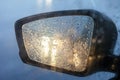 Rearview mirror with drops of water from the rain and a car with headlights. Selective focus, shallow DOF Royalty Free Stock Photo