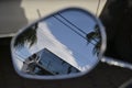 Motorcycle rear view mirror in close up, with reflection in the background of a building Royalty Free Stock Photo