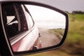 Rearview mirror reflection of a car on a dusty road Royalty Free Stock Photo