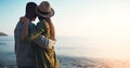 Their love is all that counts. Rearview shot of an affectionate young couple embracing each other on the beach at sunset Royalty Free Stock Photo
