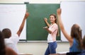 Tell me the answer.... Rearview shot of a group of students raising their hands during class. Royalty Free Stock Photo