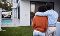 This dream home is finally ours. Rearview shot of a young couple standing outside their new home. Royalty Free Stock Photo