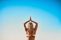 Focus on the good. Rearview shot of a young woman practicing yoga on the beach. Royalty Free Stock Photo