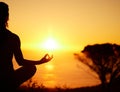 Rearview silhouette yoga woman meditating with legs crossed for outdoor practice in remote nature. Mindful person Royalty Free Stock Photo