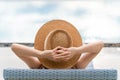 Rearview of woman in sun hat relaxing at luxury hotel tropical resort swimming pool Royalty Free Stock Photo