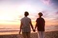 Affectionate lesbian couple holding hands watching a beach sunset Royalty Free Stock Photo