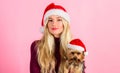 Reasons to love christmas with pets. Girl attractive blonde hold dog pet pink background. Woman with puppy wear santa