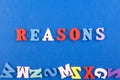 REASONS word on blue background composed from colorful abc alphabet block wooden letters, copy space for ad text. Learning english Royalty Free Stock Photo