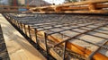The rebar framework taking shape underneath a layer of wooden boards preparing for concrete to be poured