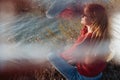 Rebel careless ginger girl in red sweater smoking near sea in sunrise Royalty Free Stock Photo