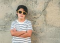 Rebellious boy with sunglasses next to a wall Royalty Free Stock Photo