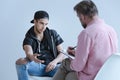 Rebellious spanish man talking to professional psychologist during meeting