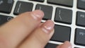 Reboot button on computer keyboard, female hand fingers press key