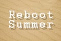 Reboot summer written on yellow sand background