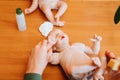 Reborn, realistic caucasian newborn baby doll lying on table in puppeteer's workshop, top view.