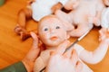 Reborning, handmade craft doll. Close-up puppet master holding realistic doll of newborn caucasian baby looking at camera