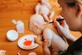 Reborning, handmade craft toy, hobby concept. Woman craftsman decorating caucasian newborn doll, painting brush hair on head