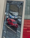 Rebound in glass building of red car on street in Pilsen city Royalty Free Stock Photo