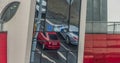 Rebound in glass building of red car on street in Pilsen city