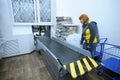 At the receipt and delivery room of post office: postal worker standing by a belt conveyor